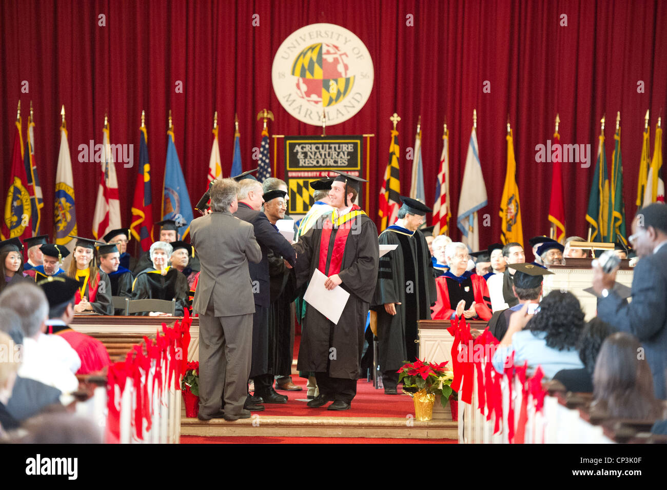 Male student receiving diploma at college graduation Stock Photo