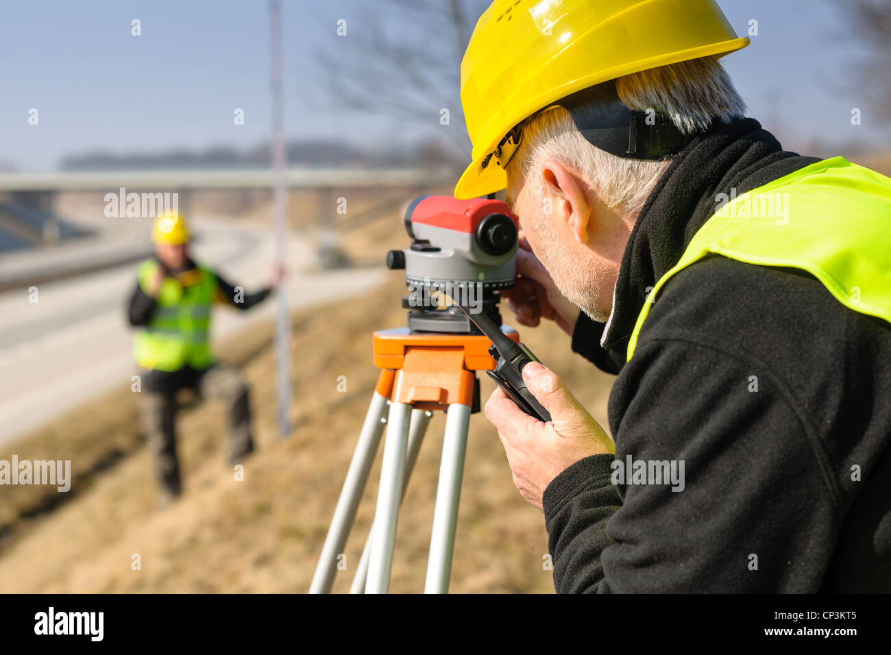 Land surveyors on highway measuring with theodolite Stock Photo Alamy