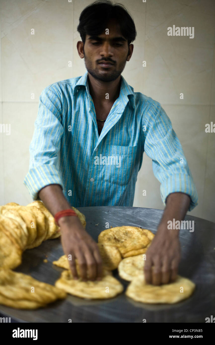 A worker at the Sitaram chole bhature wala heats up bhature for customers, Delhi, India. Stock Photo