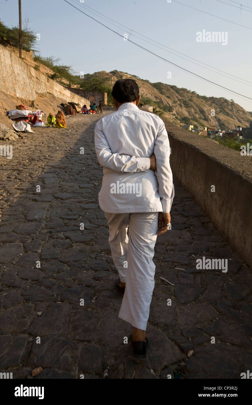 A man walks up the mountainside at Galta and the Surya Mandir (known as the Monkey Temple) Jaipur, India Stock Photo