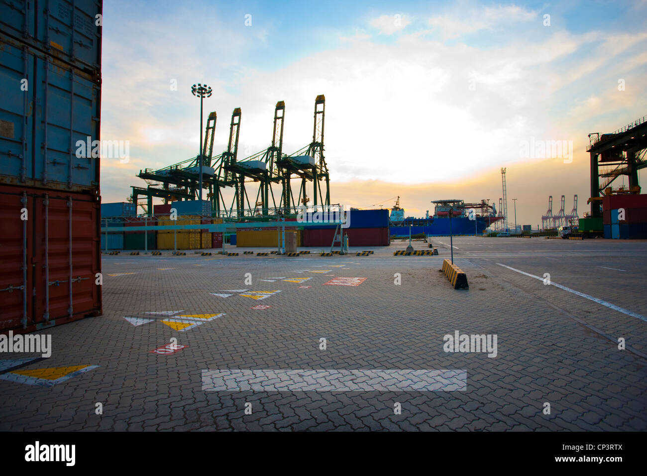 View of cranes, containers and cargo ships at dusk Stock Photo - Alamy