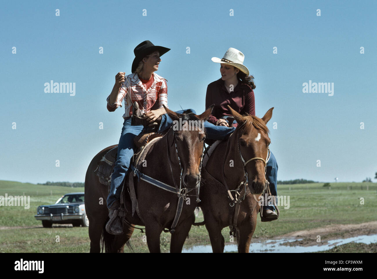 young American women wearing cowboy hats riding horses Stock Photo Alamy
