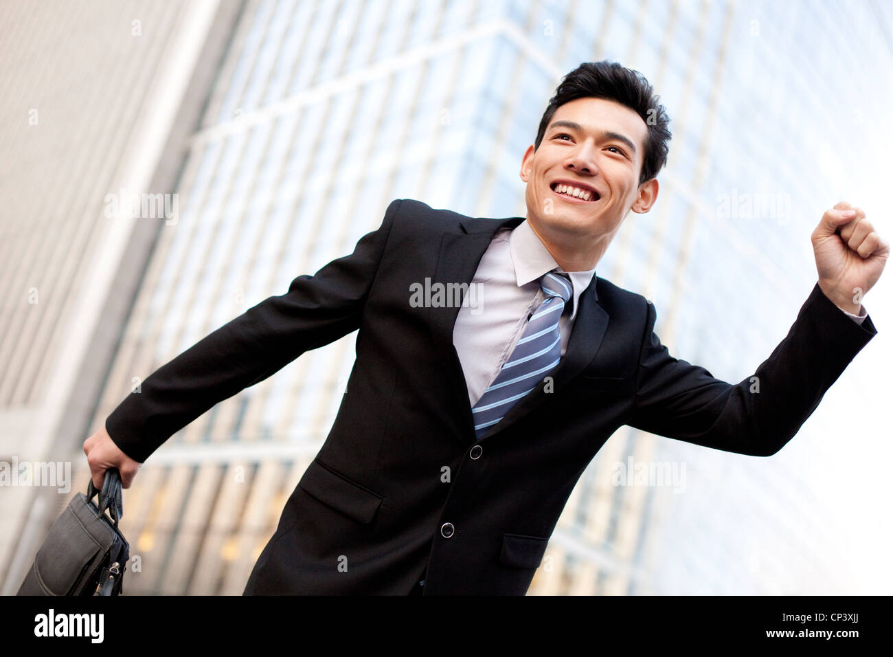 A businessman outside office buildings running Stock Photo - Alamy
