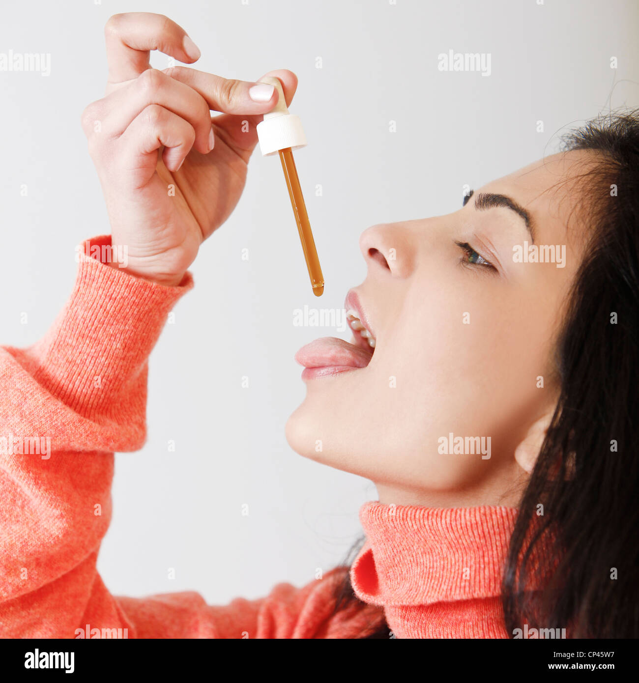 Close-up of a woman while dosing homeopathic drops Stock Photo