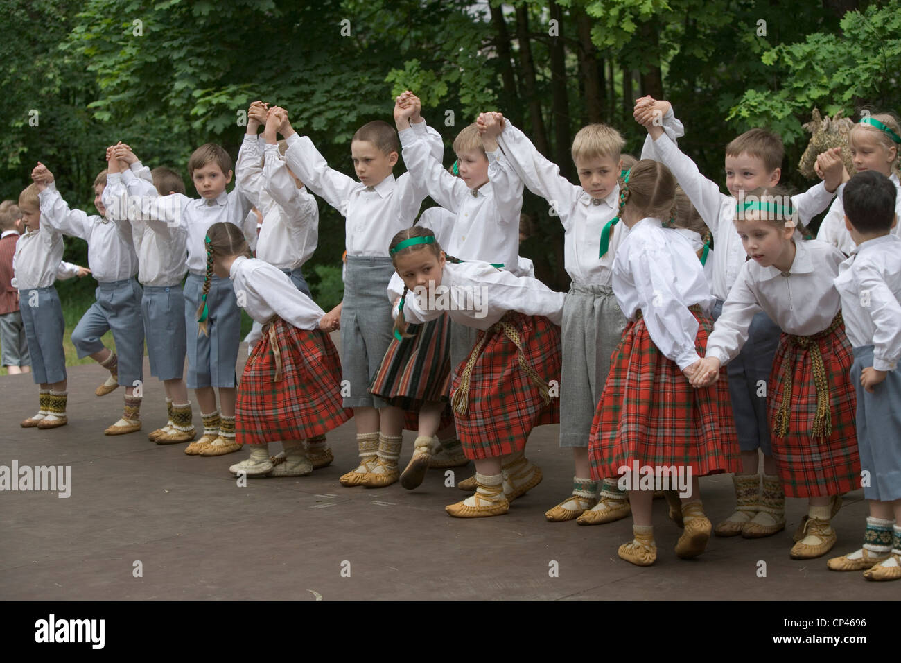 Latvia - Folk festival. Group of children in traditional costume and perform a folk dance Stock Photo