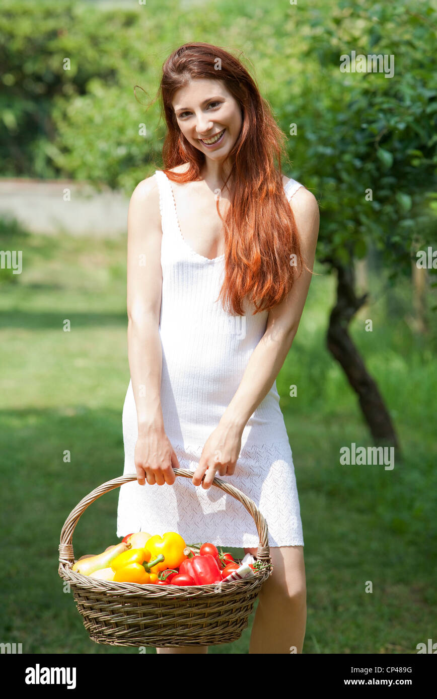 a woman with a basket of vegetables in a garden Stock Photo - Alamy