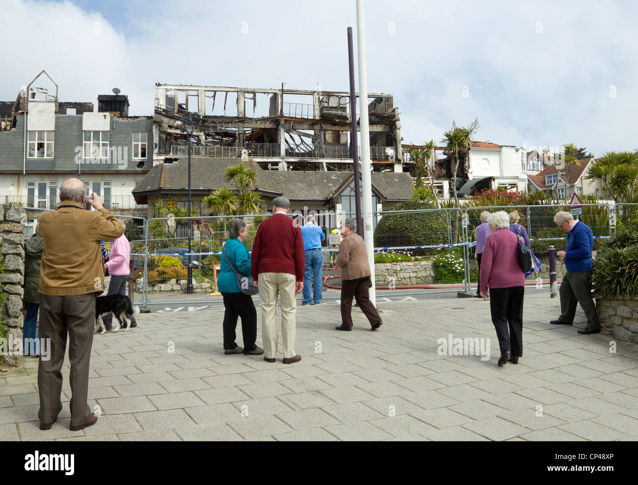 People looking at the burnt out remains of the Best Western Falmouth Beach Resort Hotel in Cornwall UK. Stock Photo