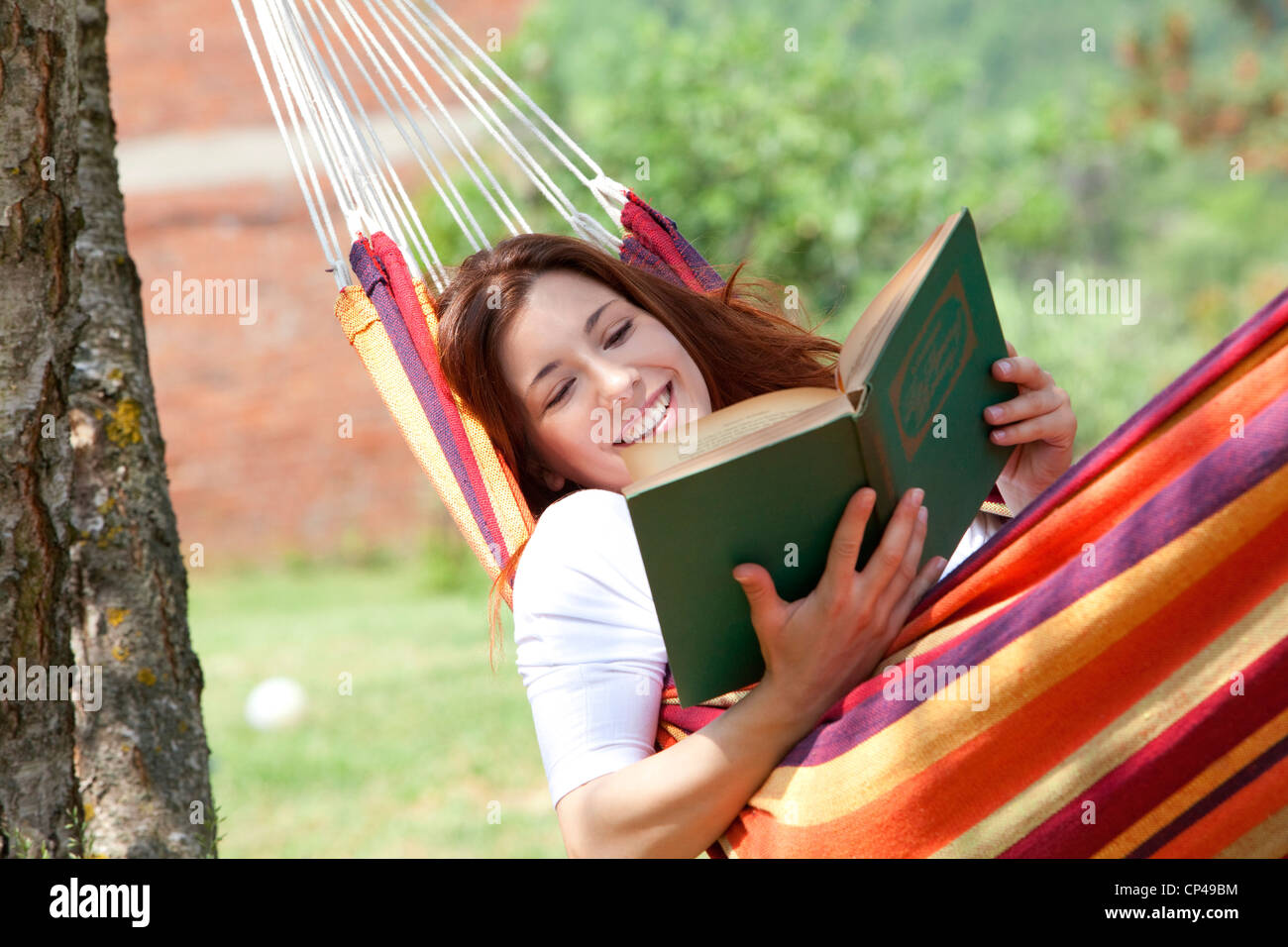 a woman reading a book lying on a hammock Stock Photo - Alamy