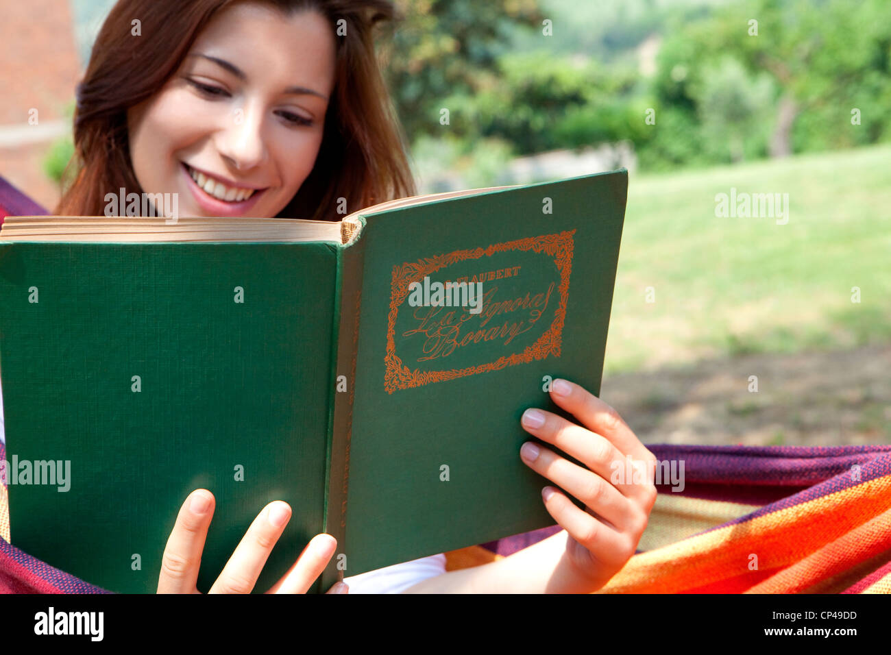 a woman reading a book lying on a hammock Stock Photo - Alamy