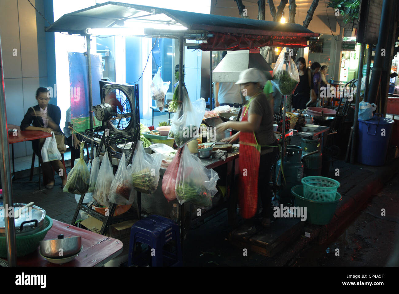 A woman cooking in street food restaurant in Bangkok , Thailand Stock