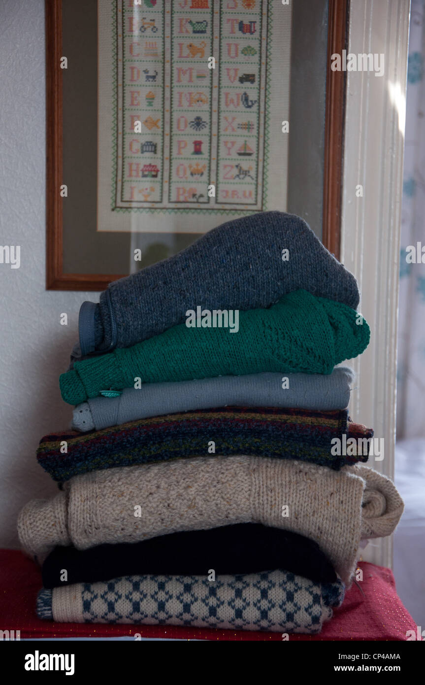 A stack of woolen jumpers in a home setting Stock Photo