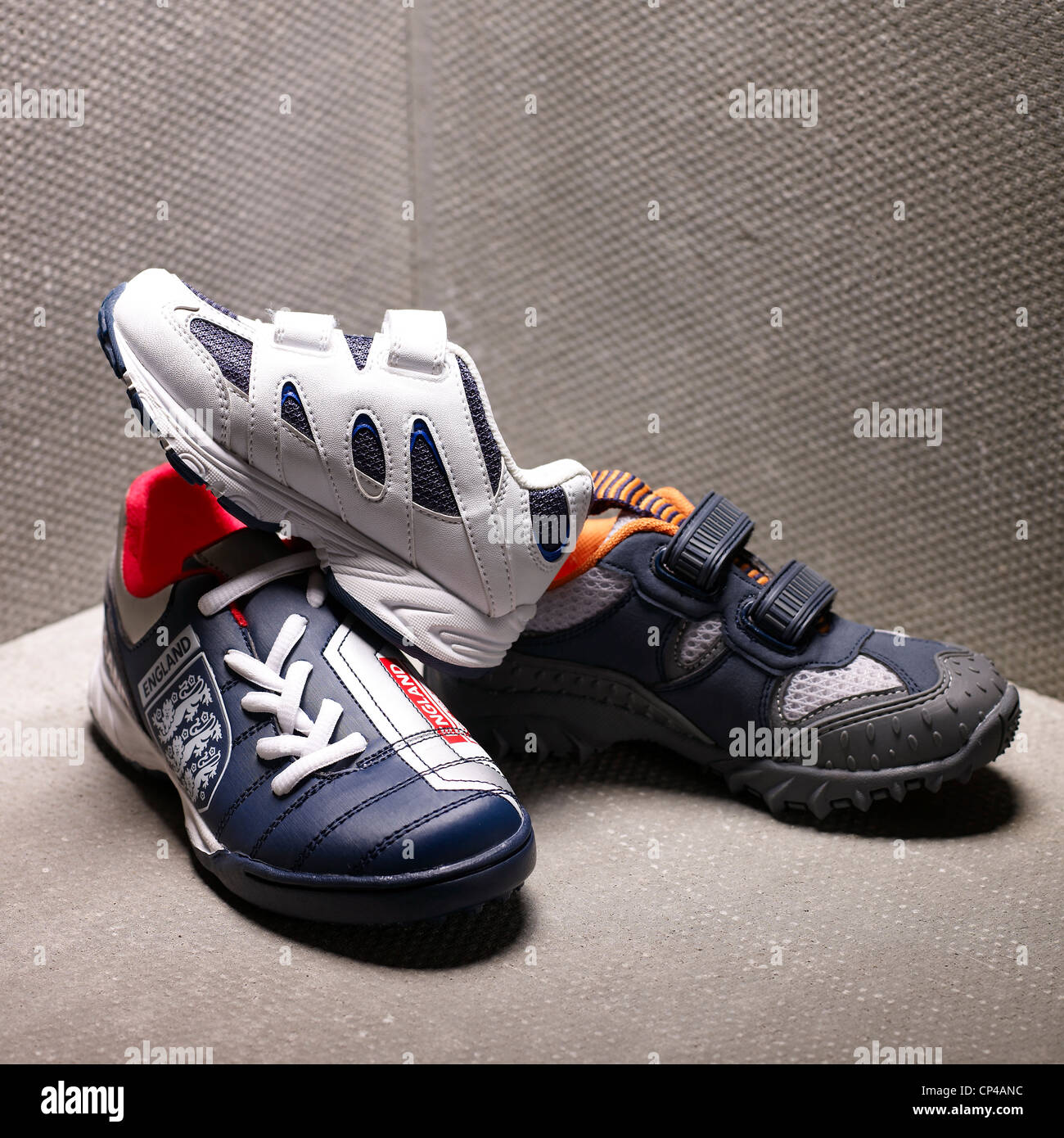 A still life shot of three childrens shoes/sneakers/trainers Stock Photo