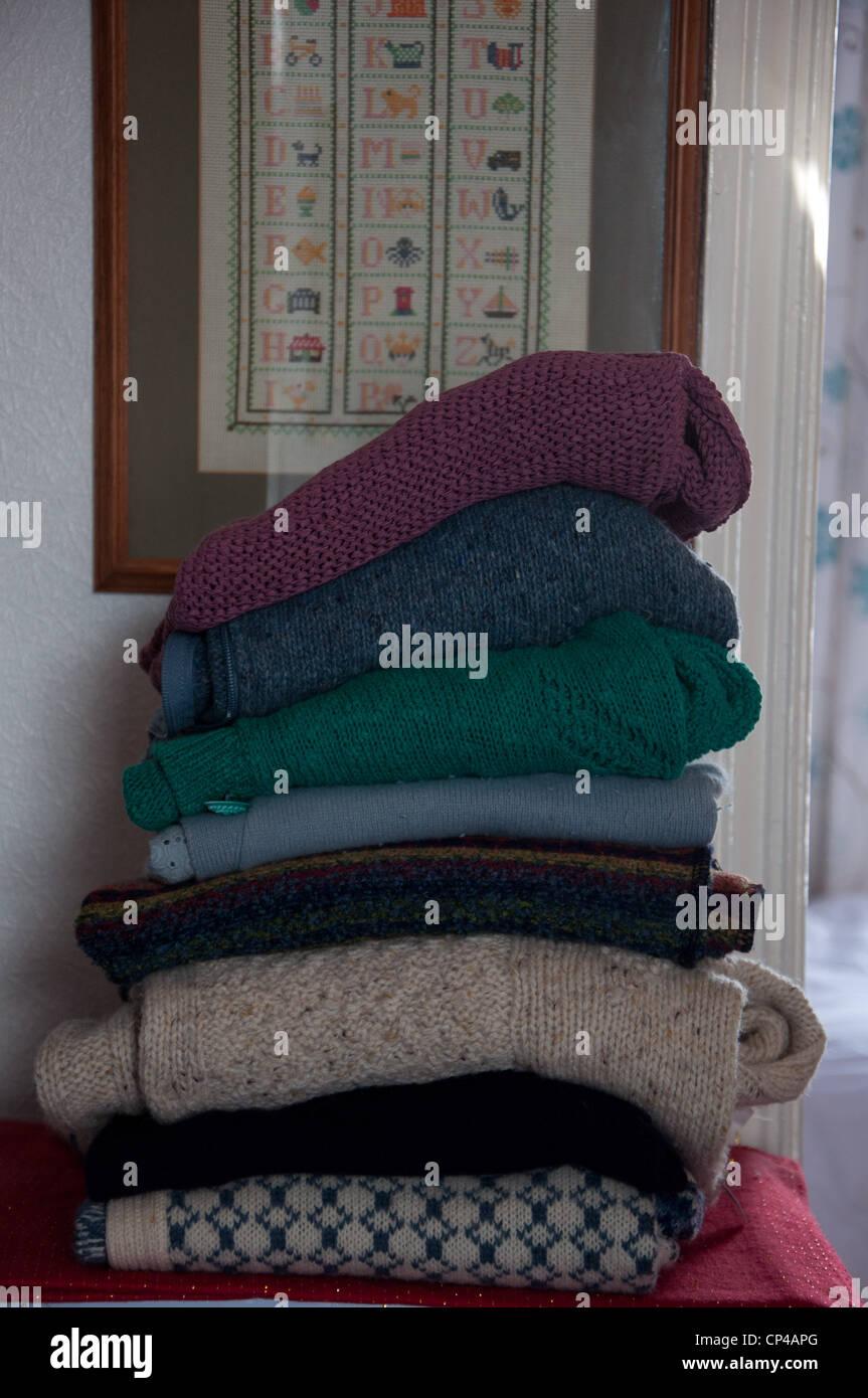 A stack of woolen jumpers in a home setting Stock Photo