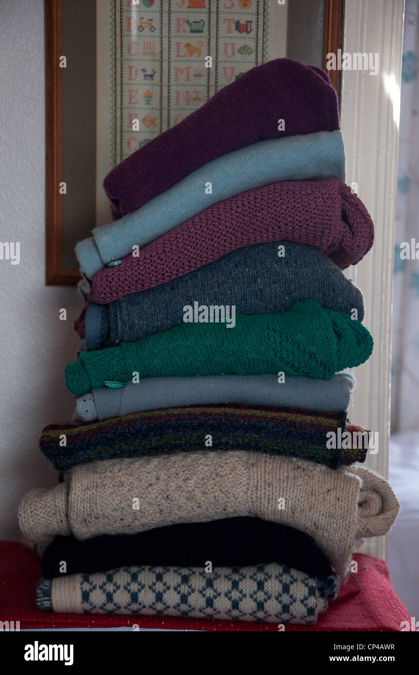A stack of  woolen jumpers in a home setting Stock Photo
