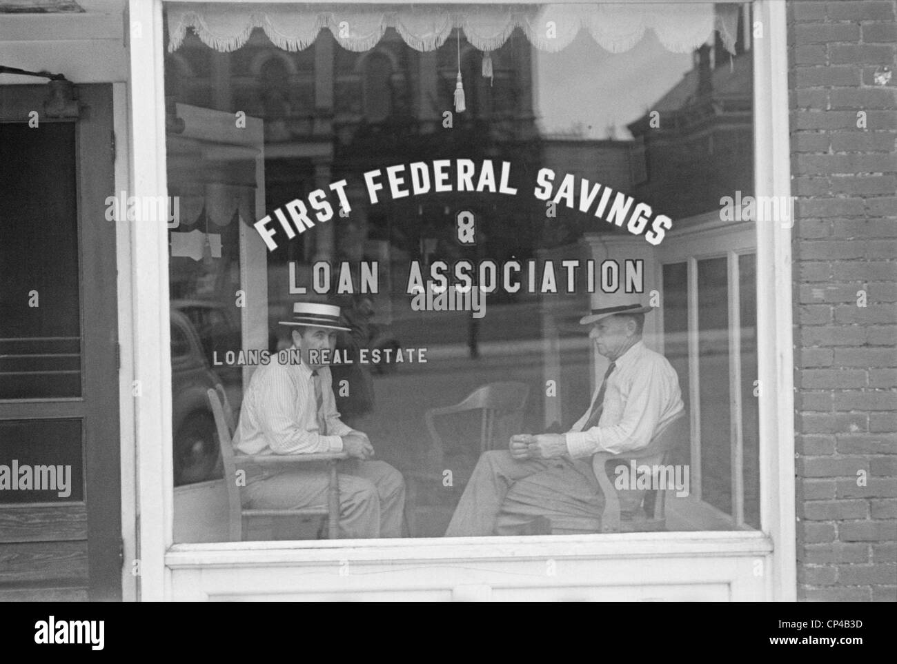 Two businessmen sit behind the storefront window of a Marion, Ohio