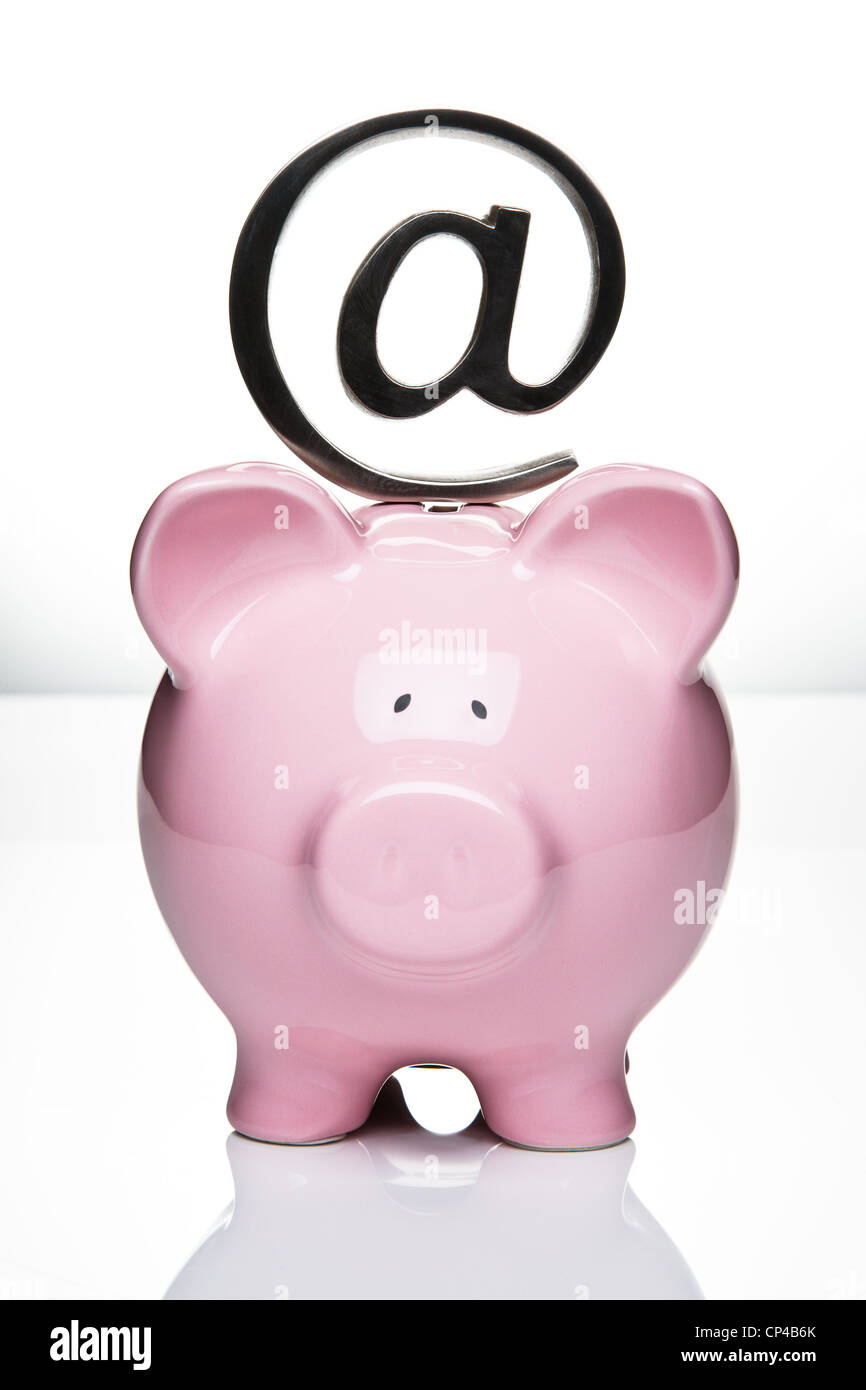 At symbol paperweight on top of a piggy bank Stock Photo