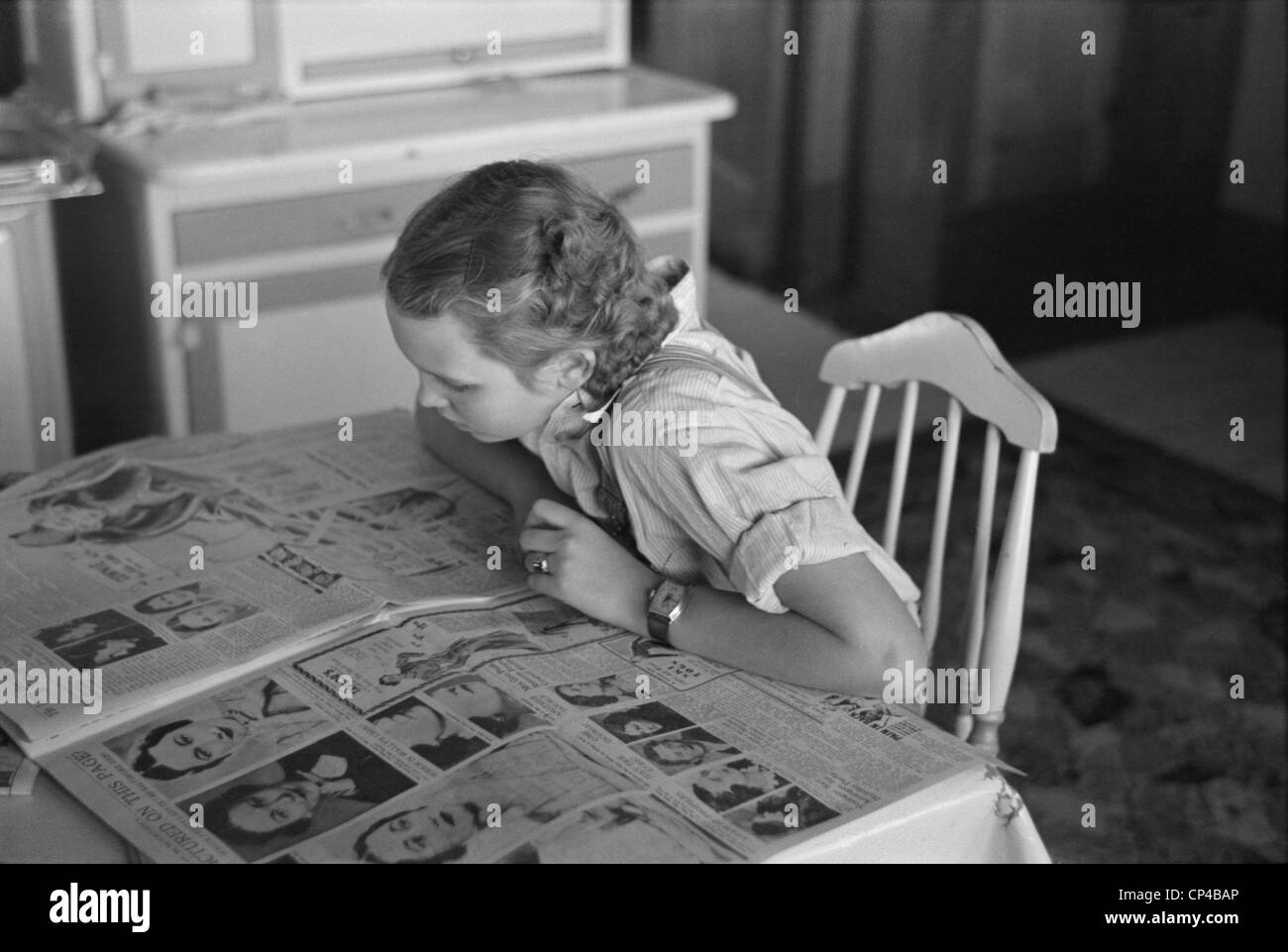 Royal scandal news. A farmer's daughter in Dickens, Iowa, reading a newspaper's pictorial article about Wallace Simpson and Stock Photo