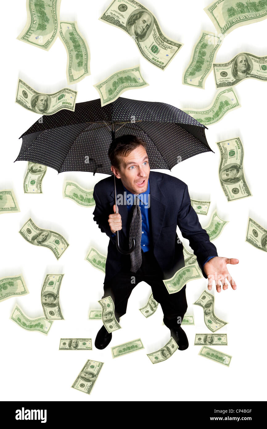 Raining money on a businessman with umbrella Stock Photo