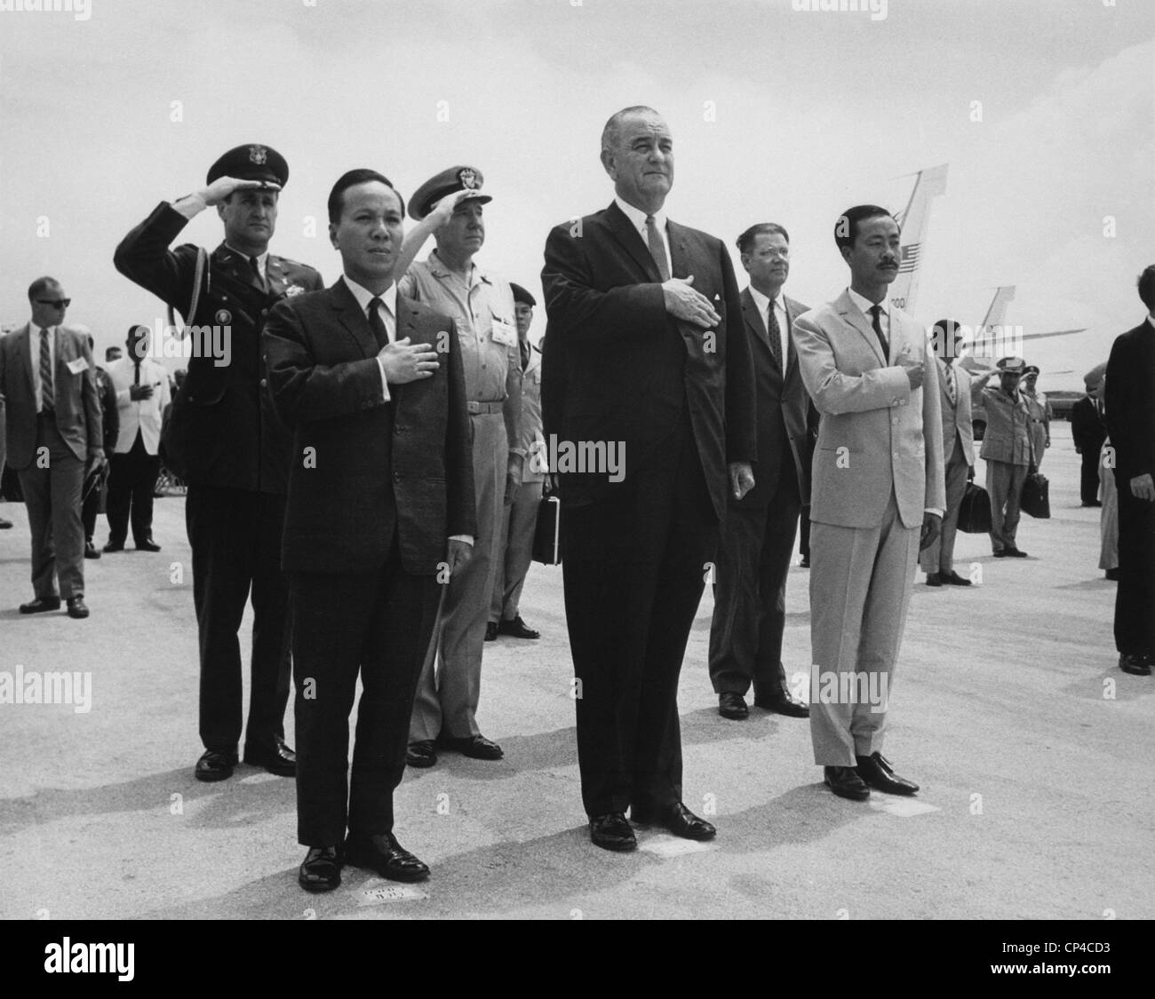 US-South Vietnam summit meeting. Nguyen Van Thieu, President Johnson and Nguyen Cau Ky salute during the playing of the US and Stock Photo