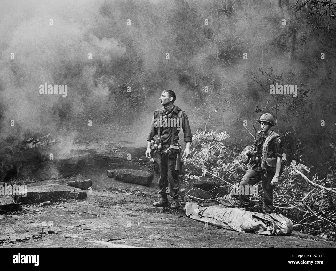 Vietnam War. Two American GIs standing over the body of a fallen comrade after the day's battle was finished. Long Khanh Stock Photo