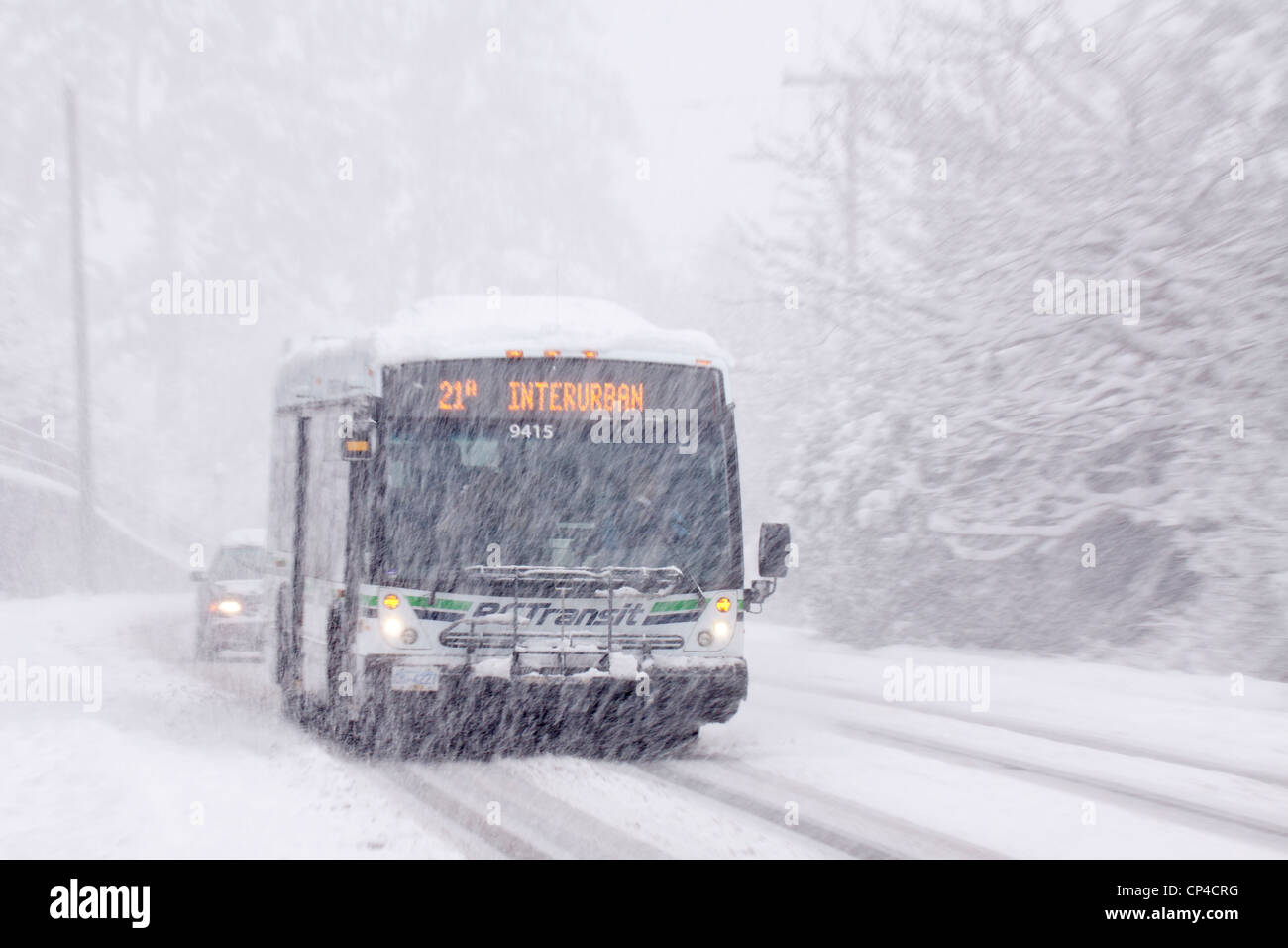 City transit bus on rural road during winter blizzard-Victoria, British Columbia, Canada. Stock Photo