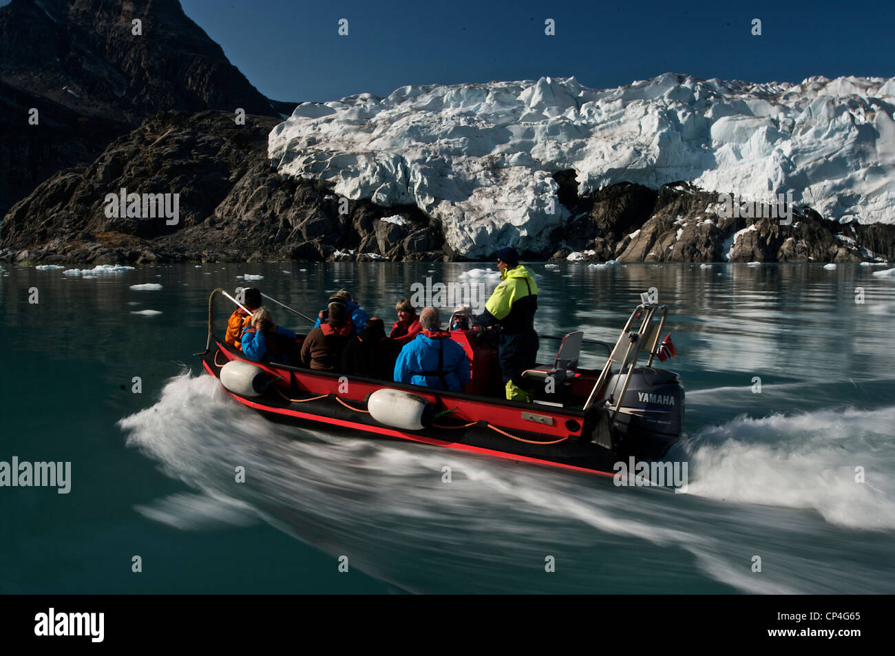 Greenland - West Coast. Tourists in excursion on a rubber boat through rocks covered by ice and icebergs. Stock Photo