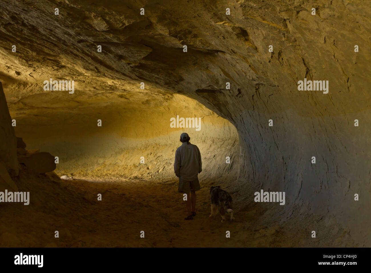 Man and his dog in a cave in Grand Staircase-Escalante National Monument, Utah Stock Photo
