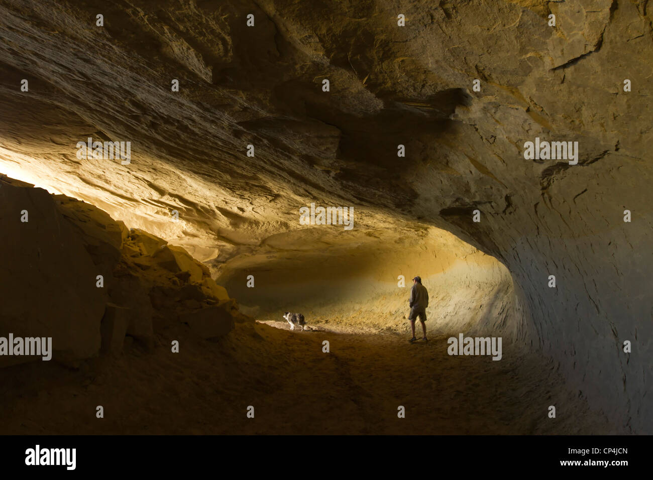 Man and his dog in a cave in Grand Staircase-Escalante National Monument, Utah Stock Photo