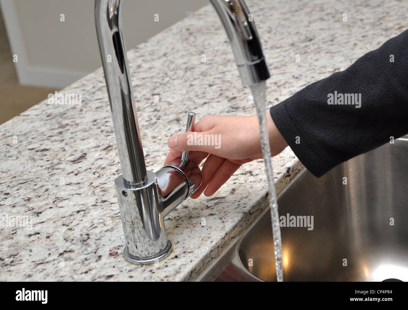 Woman turns on tap water Stock Photo Alamy