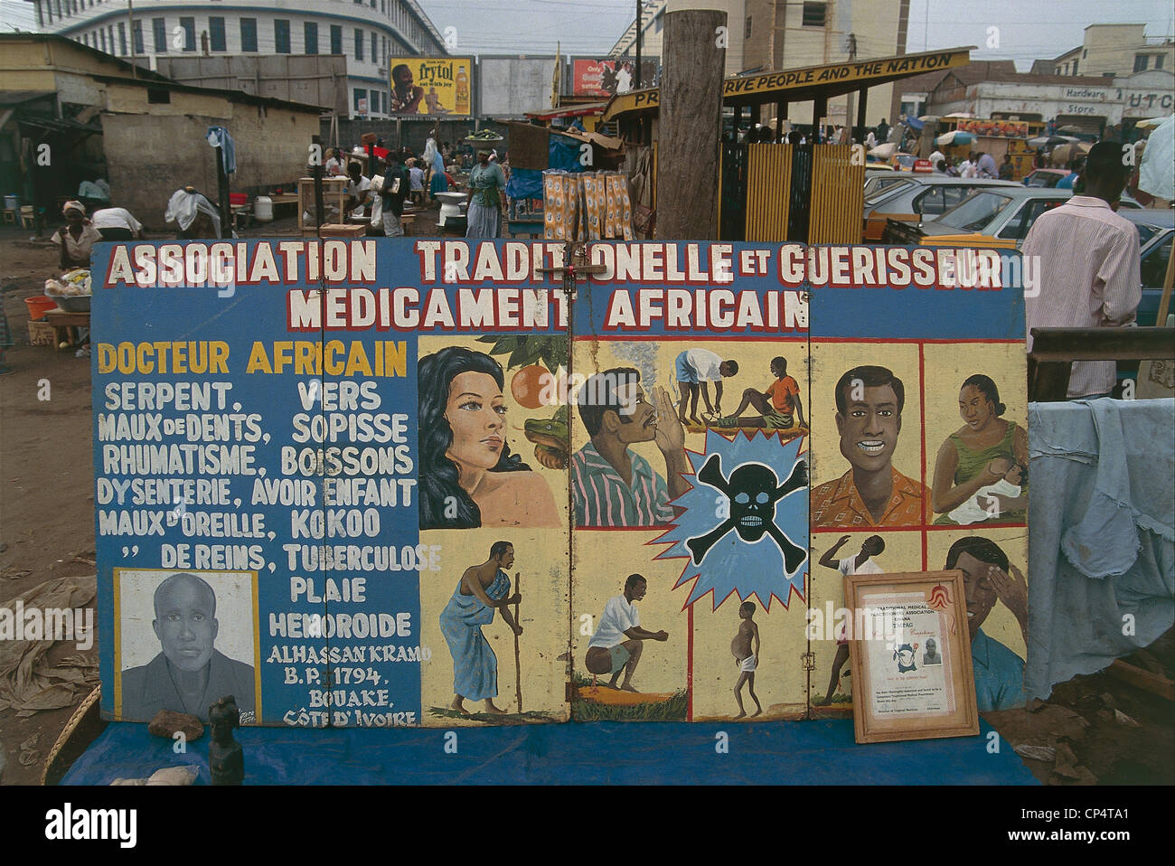 Ghana - Kumasi - propaganda posters of the public health prevention. In the background, a market. Stock Photo