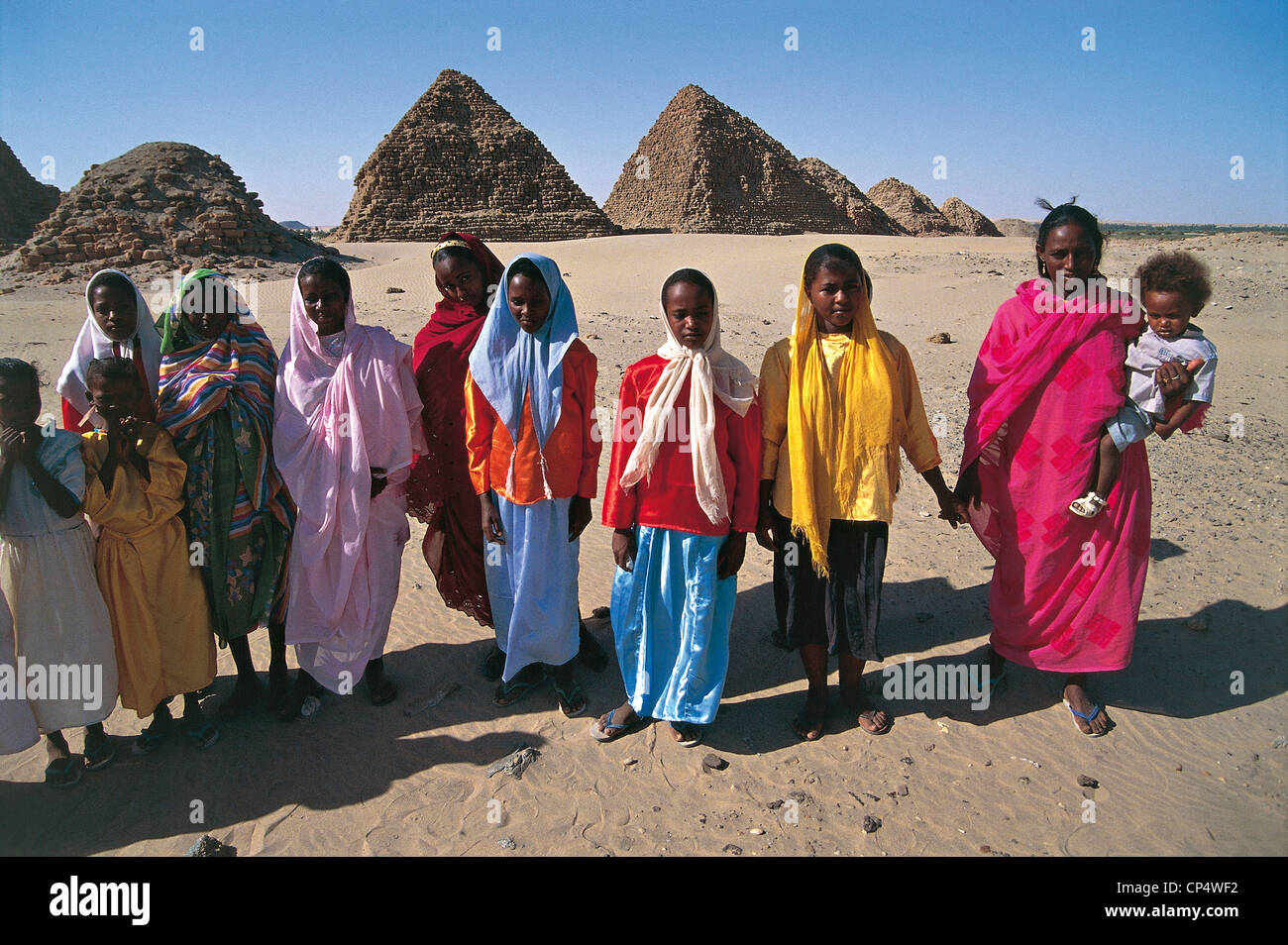 Sudan - Nubia - Nuri. Women with children, against the backdrop of the pyramids of the pharaohs blacks Stock Photo