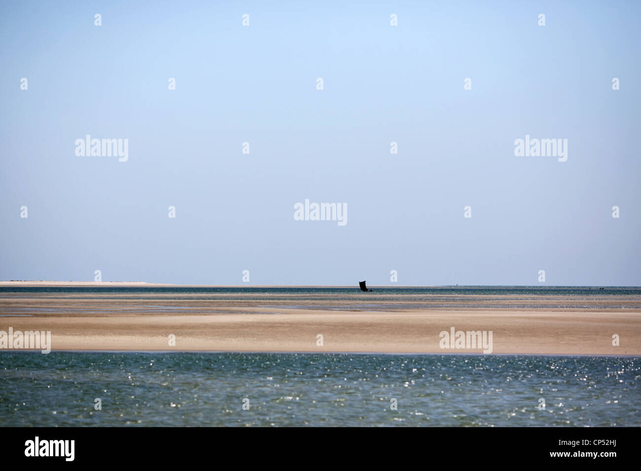 An outrigger canoe sailing by the sand banks at Belo-Sur-Mer, Western Madagascar, Africa Stock Photo