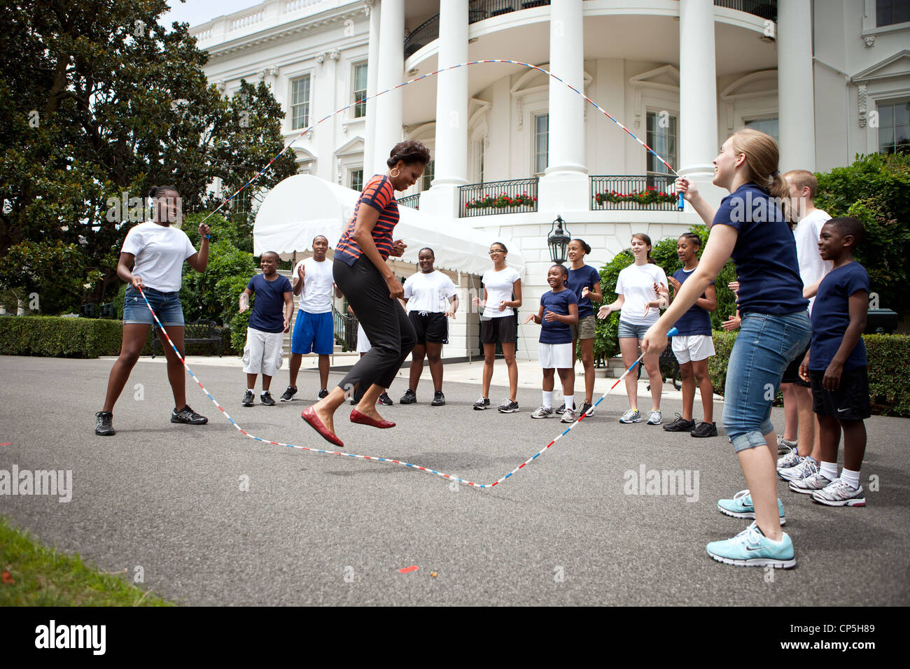 First Lady Michelle Obama and kids double-dutch jump rope during a taping for the Presidential Active Lifestyle Award (PALA) Stock Photo