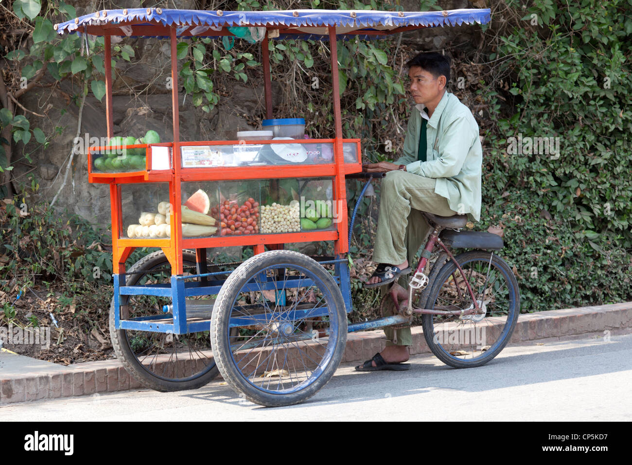 A street hawker waiting for customers with his mobile cart (Luang Prabang - Laos) Vendeur des rues attendant des clients (Laos). Stock Photo