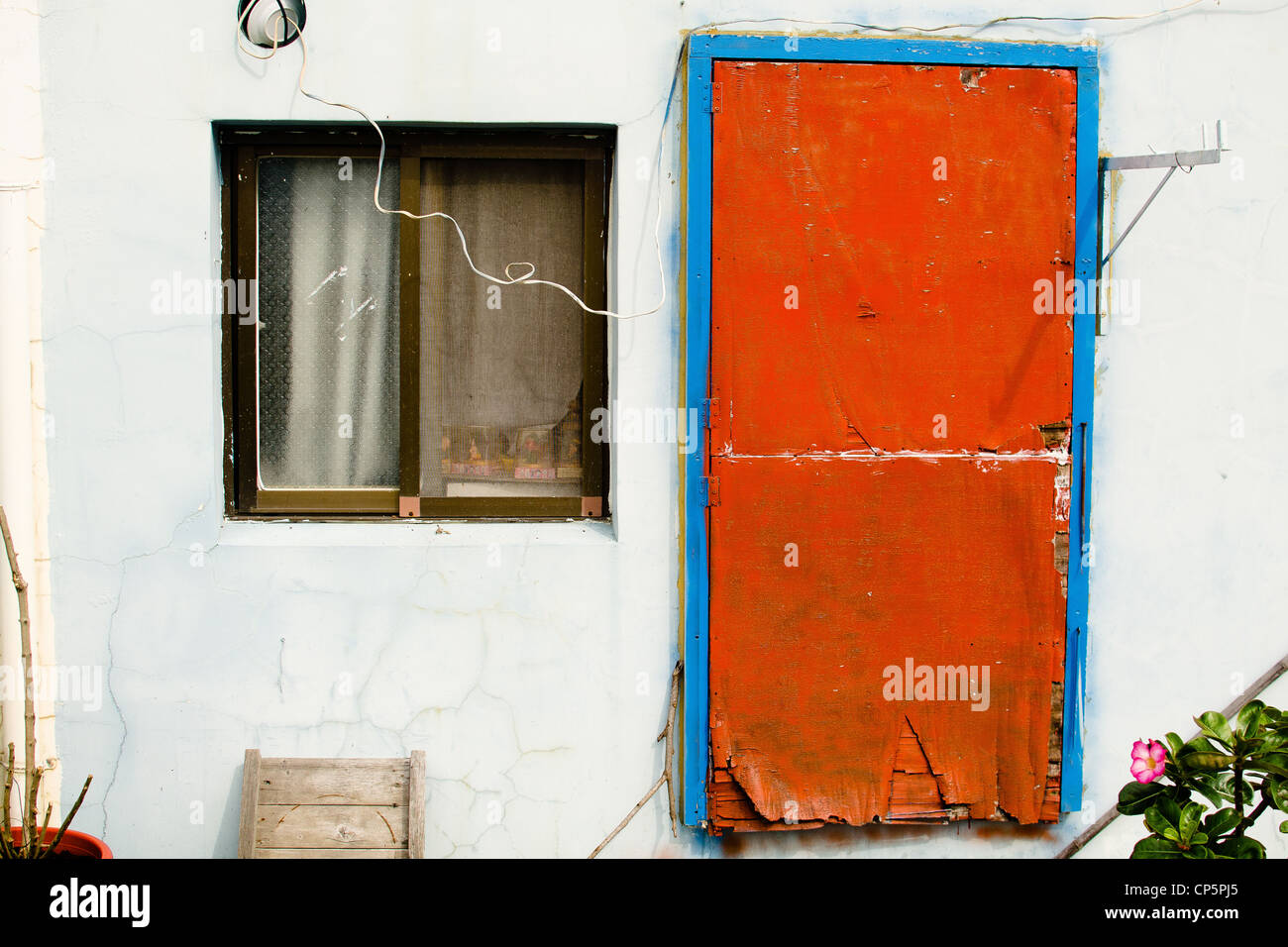 Colourful Navy Blue Wall Of A Small House With Red Doors