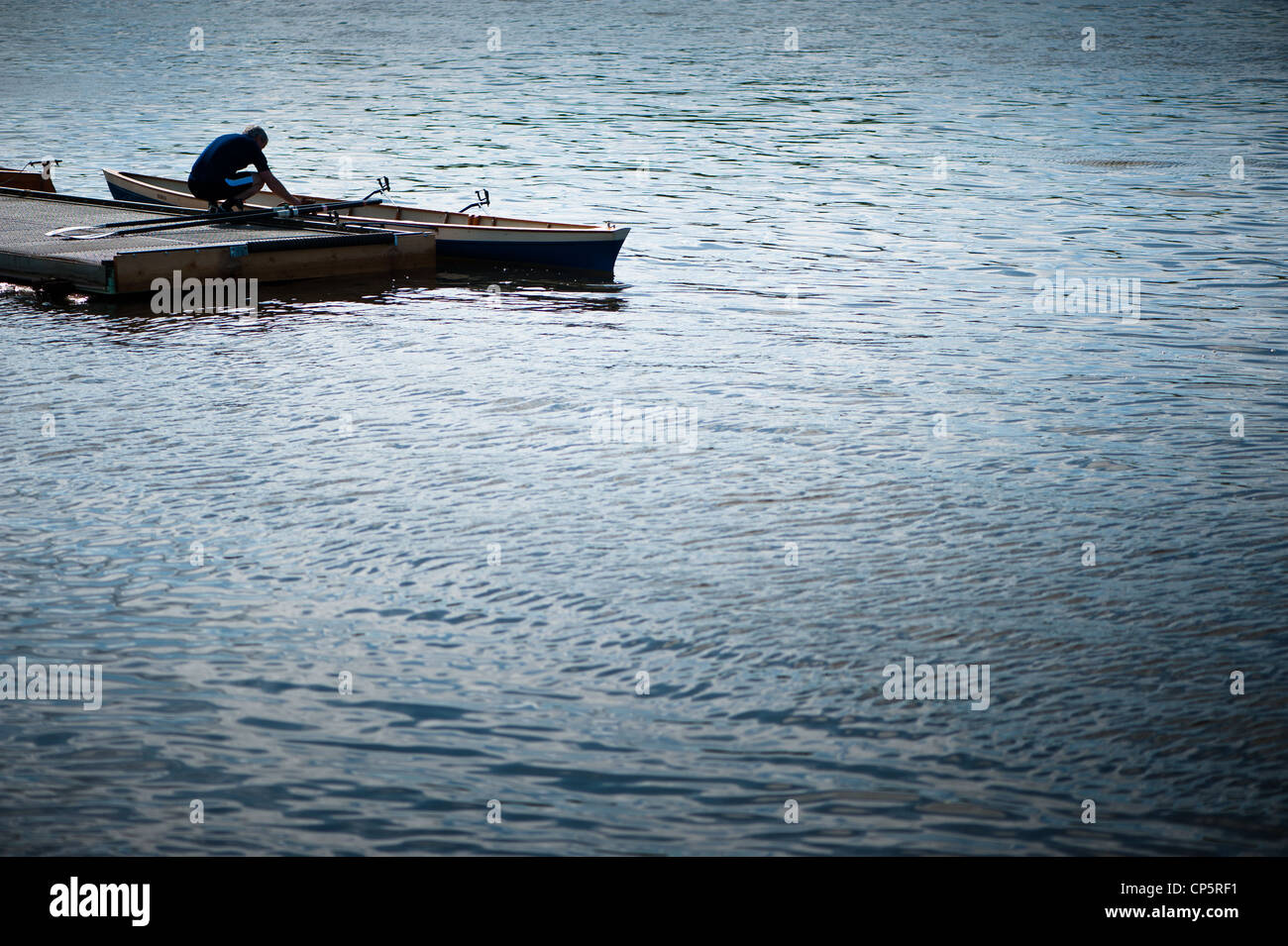 Man preparing rowboat on pontoon Stock Photo
