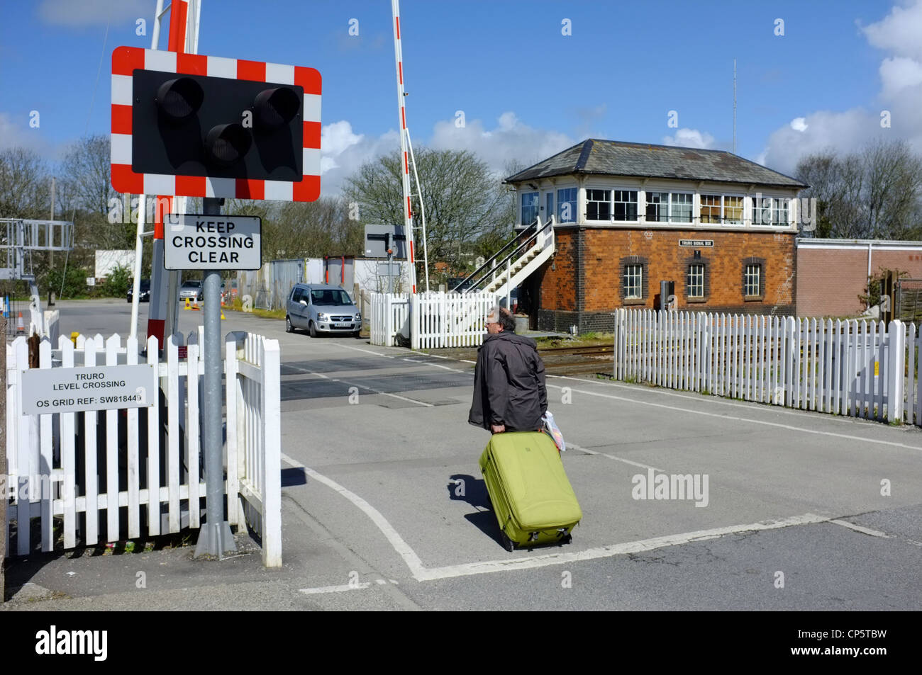 A man walks across the level crossing at Truro Station Stock Photo