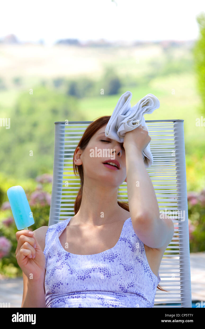 a flushed woman eating a popsicle Stock Photo