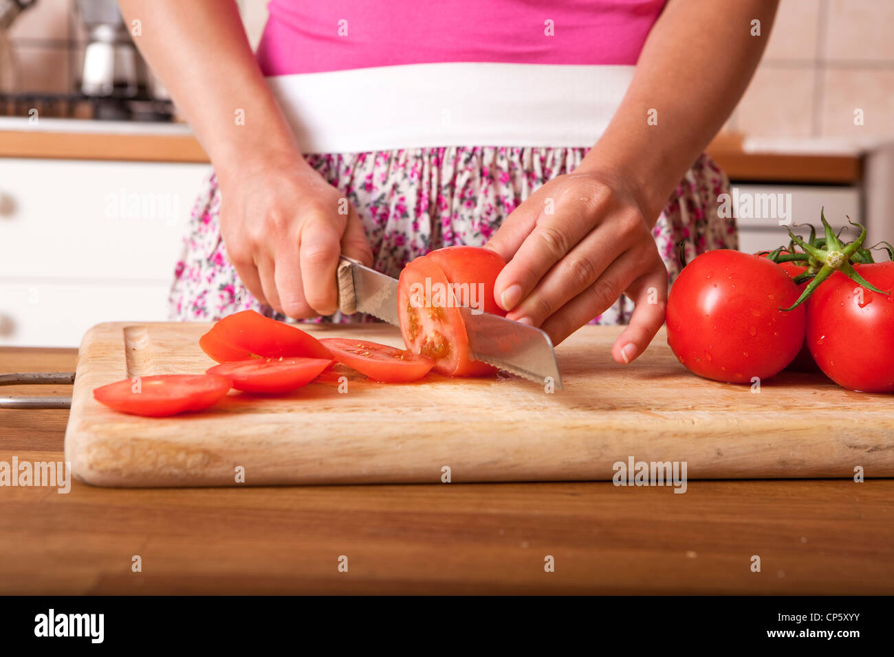 Woman slicing tomatoes Stock Photo - Alamy