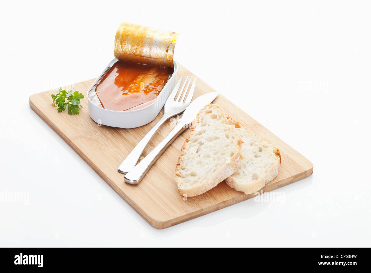 Herring fillets with tomato sauce in tin on chopping board Stock Photo