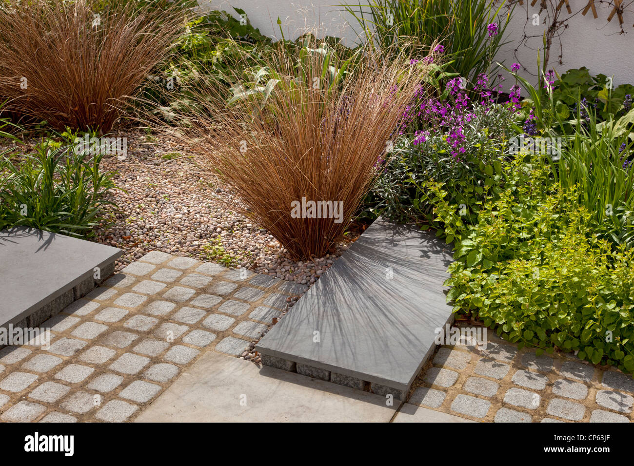 contemporary modern garden with gravel and grasses stone and slate path Stock Photo