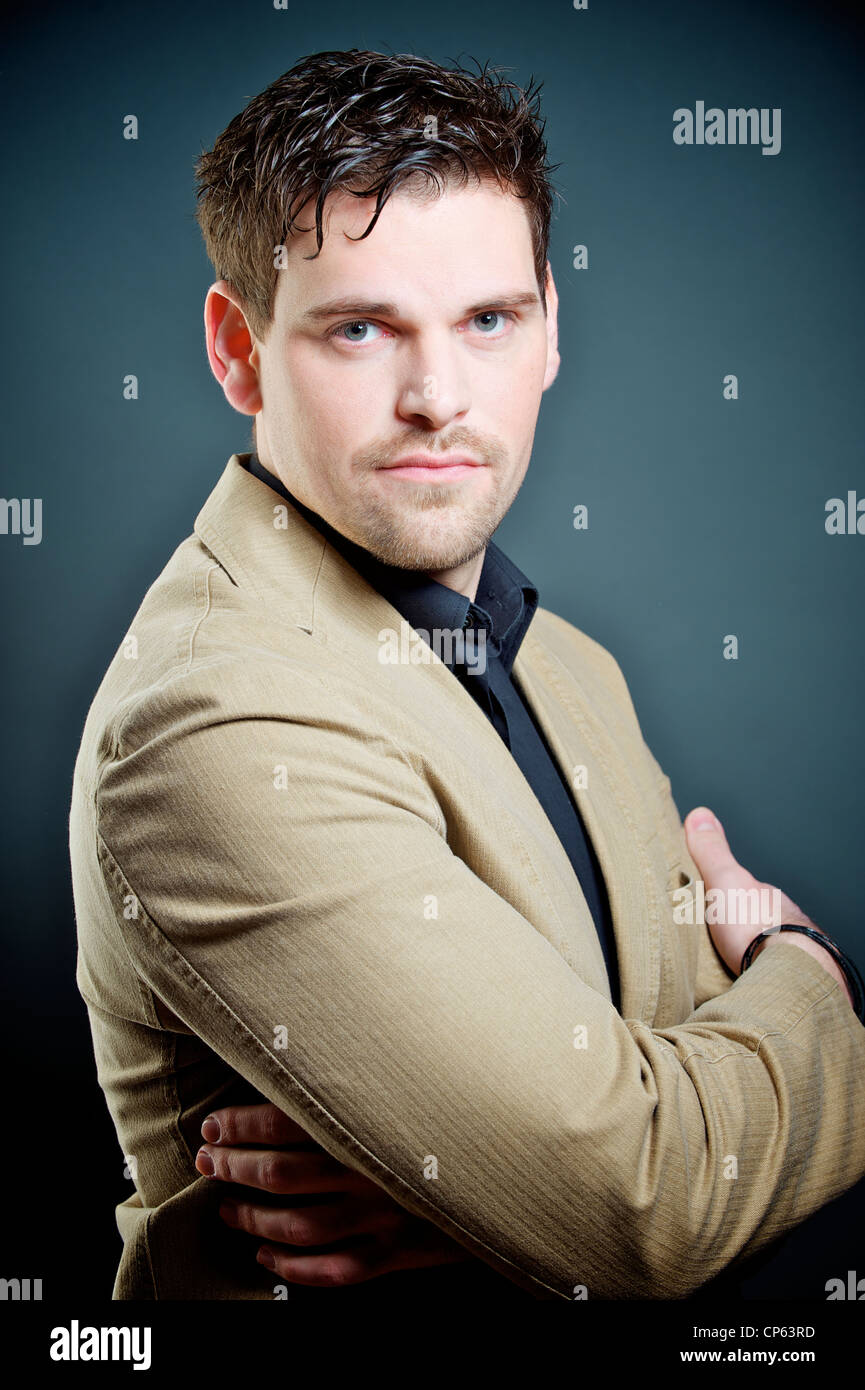 good looking business man watching you, studio shot, arms crossed Stock Photo