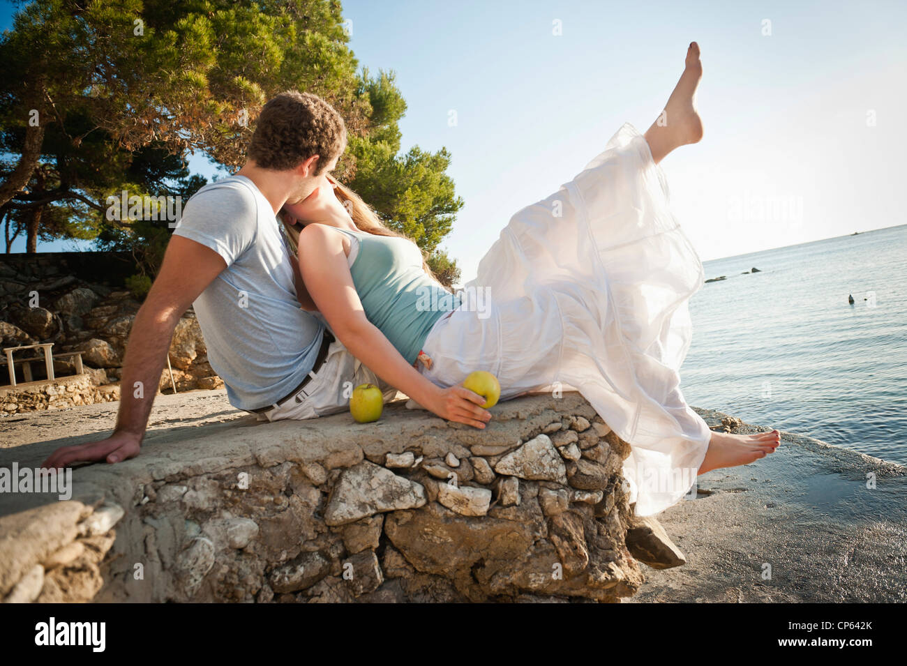 Spain, Mallorca, Couple sitting on beach, smiling Stock Photo