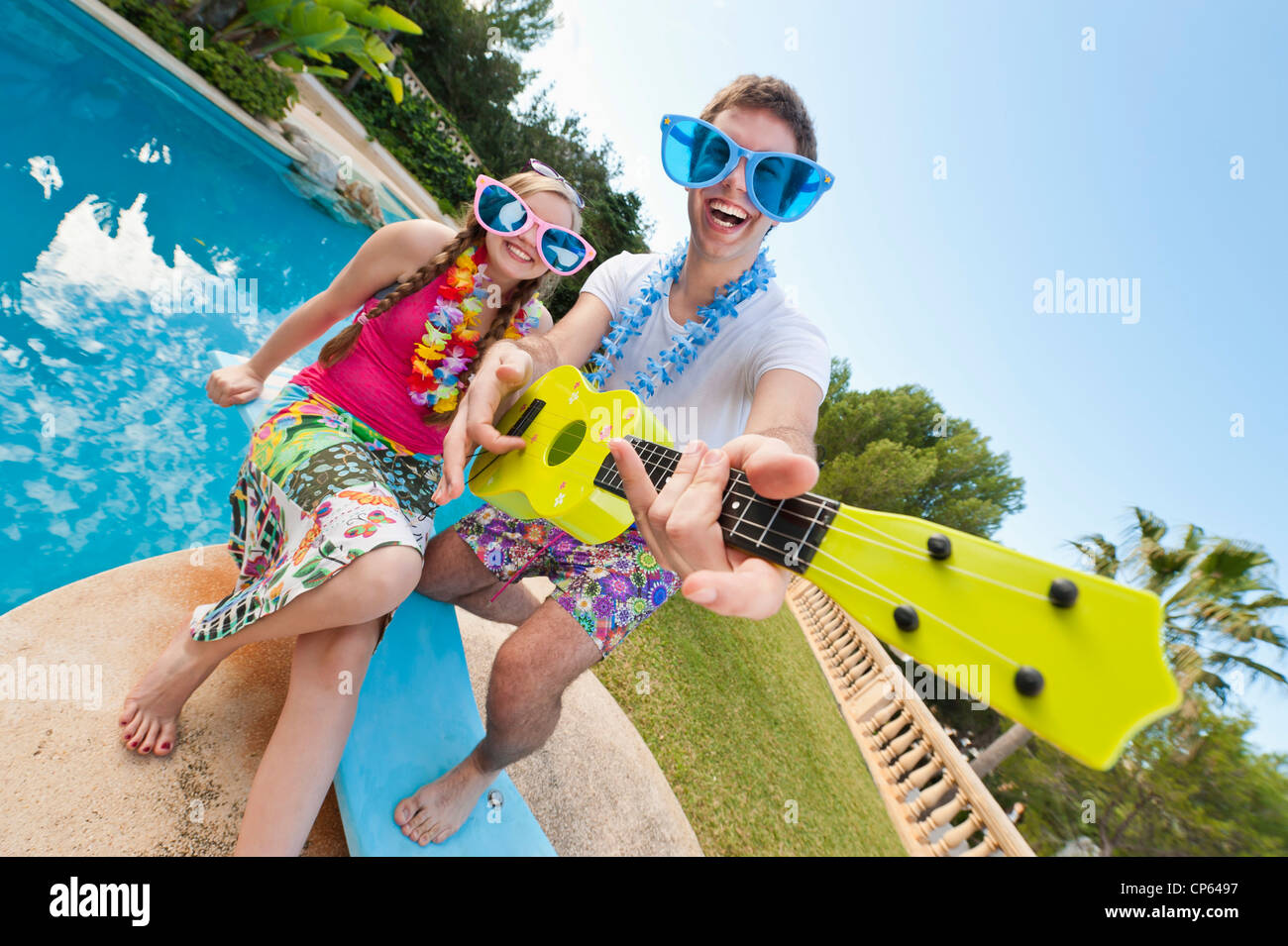 Spain, Mallorca, Couple playing on swimming pool, smiling Stock Photo