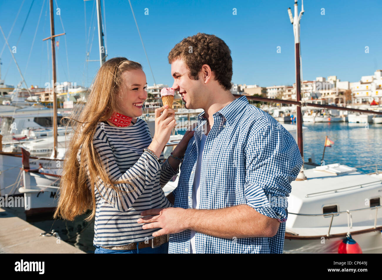 Spain, Mallorca, Couple eating ice cream at harbour, smiling Stock Photo