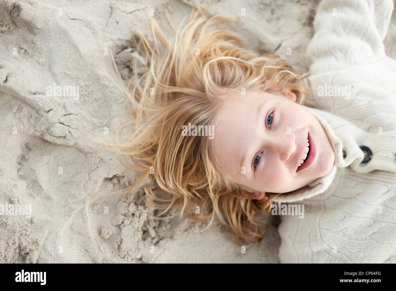 Spain, Mallorca, Boy lying on beach, smiling, portrait Stock Photo