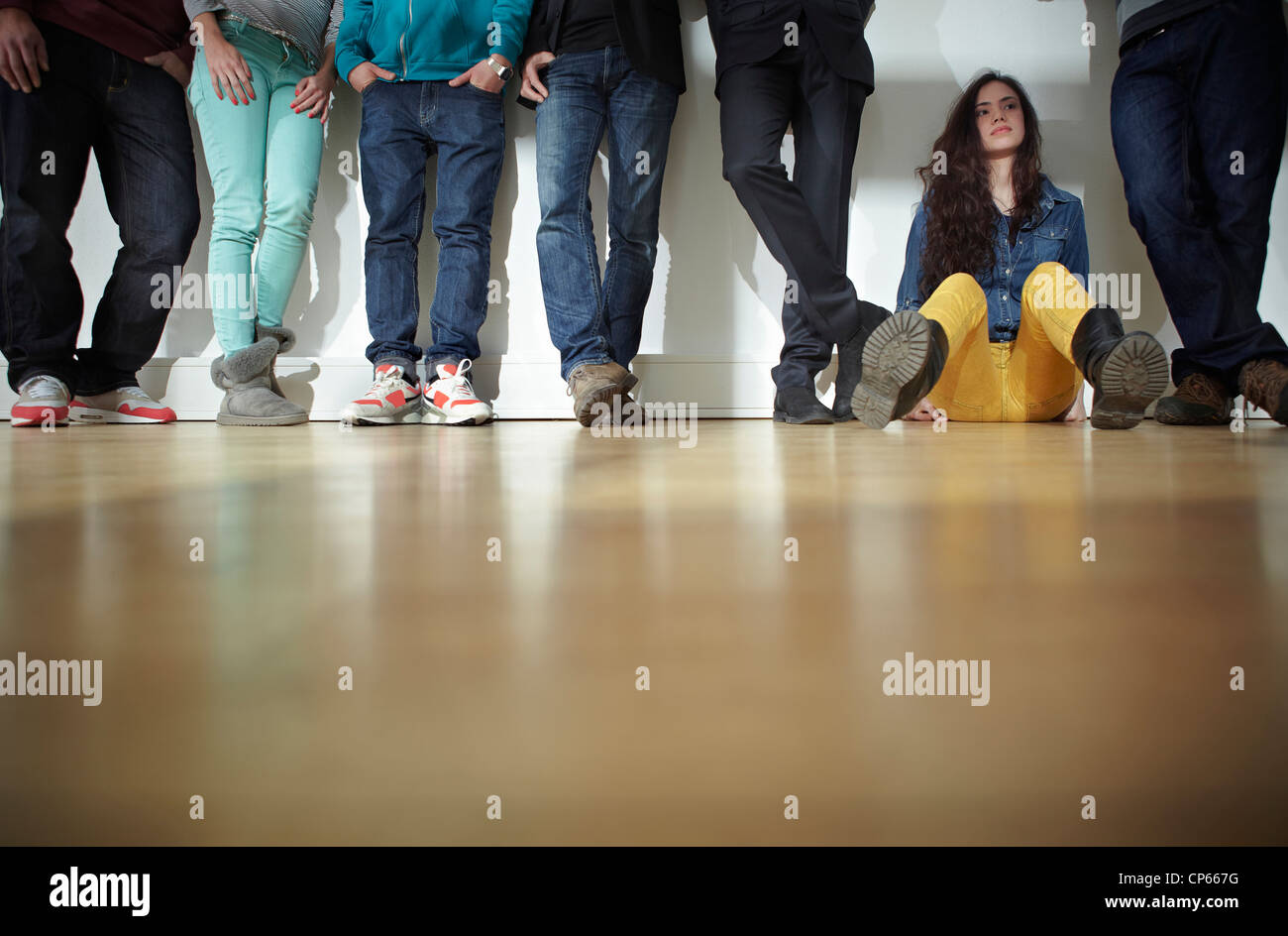 Germany, Cologne, Men and women standing and sitting on floor Stock Photo