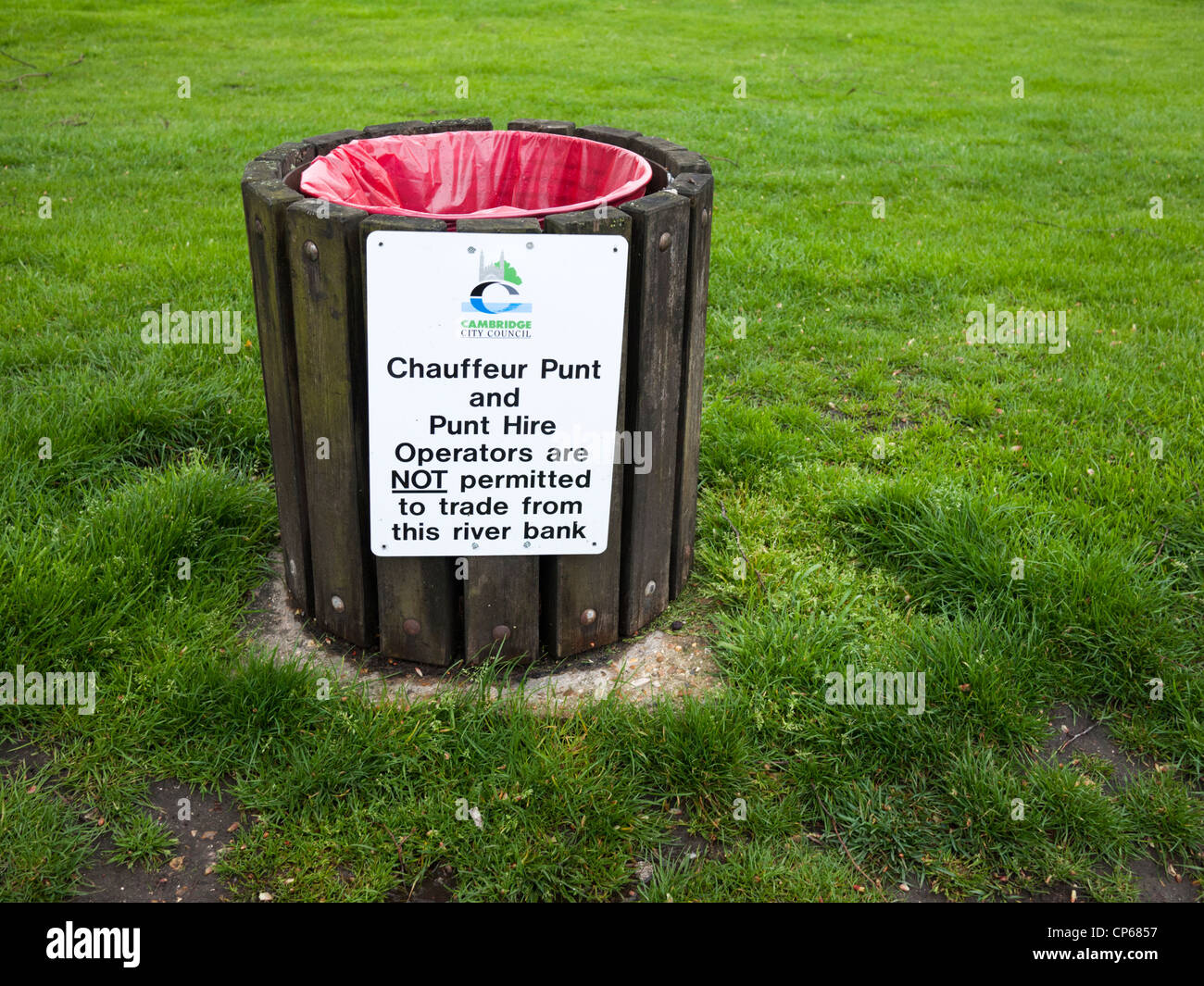 Dustbin in Cambridge with sign banning chauffeur punts or punt hire firms from operating. Sign on Jesus Green. Stock Photo