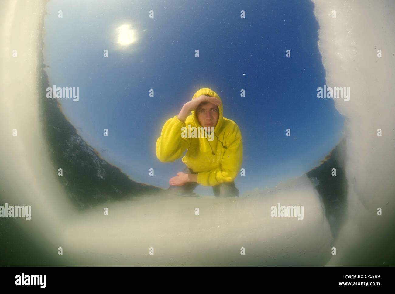 Diver looking into an ice hole, subglacial diving, ice diving, in the