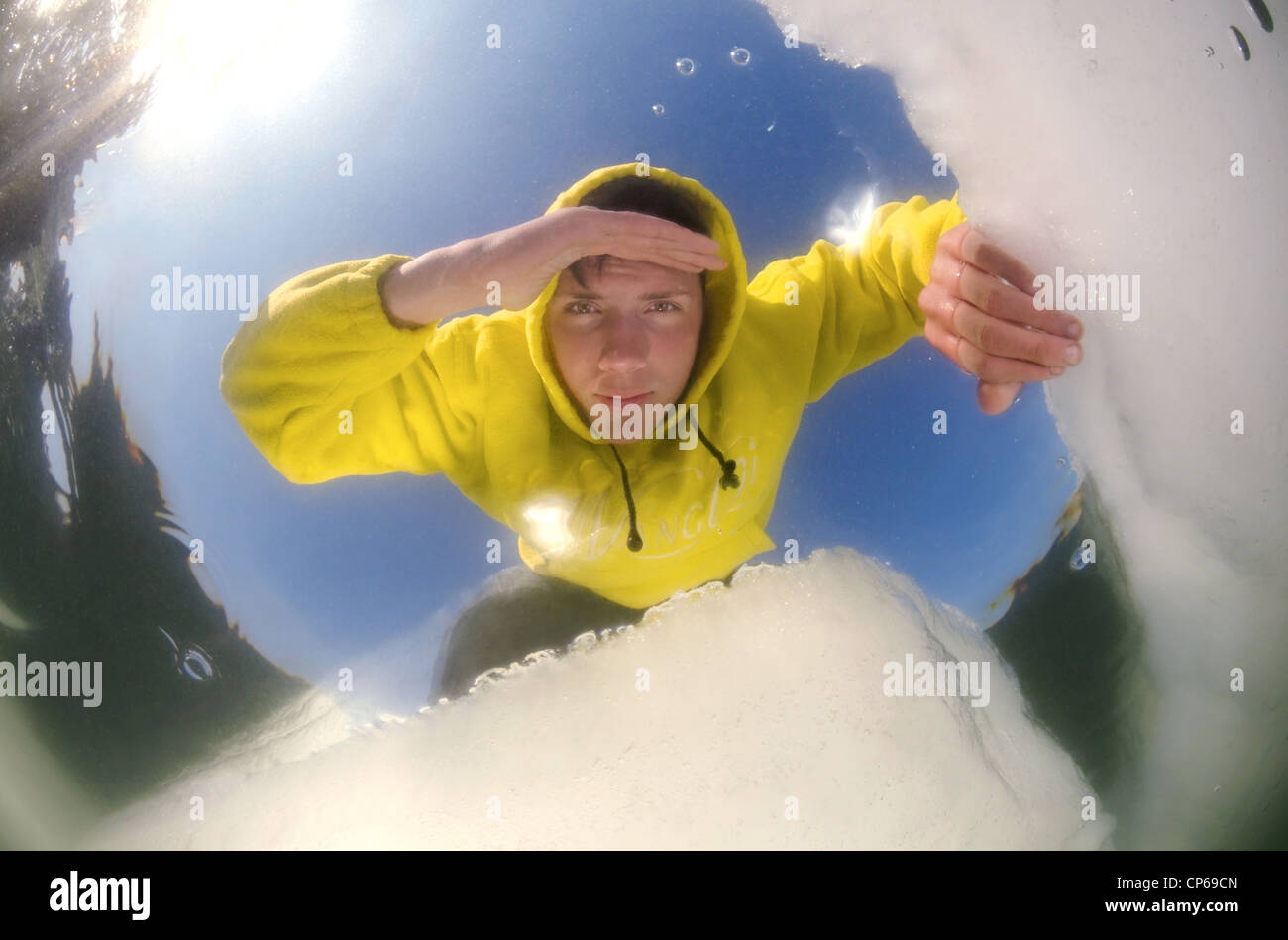 Diver looking into an ice hole, subglacial diving, ice diving, in the